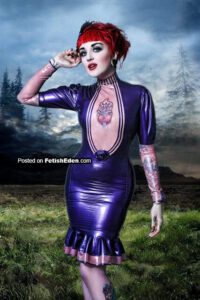 Tattooed redhead Melissa Hayward dressed in purple latex mini-dress on transparent pink latex top