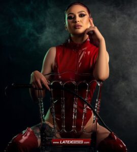 Dominatrix with whip in red PVC bodysuit