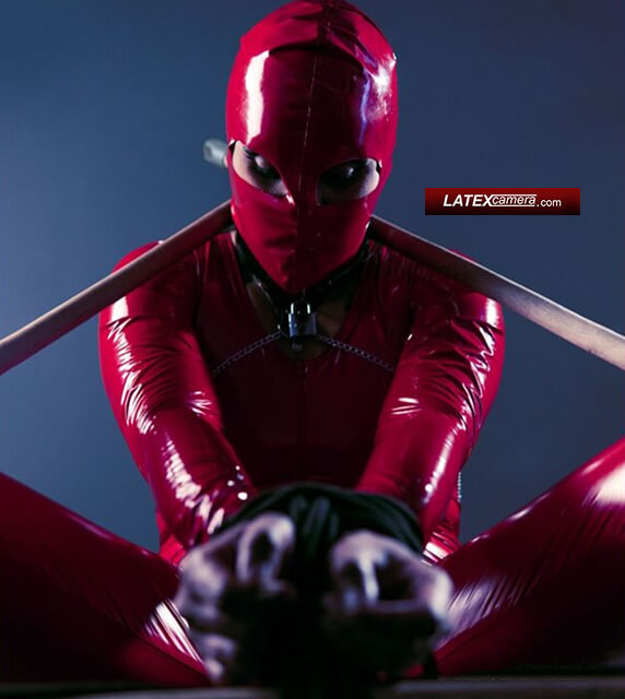 latexcamera tied up submissive in red PVC catsuit and red PVC hood Restrained sub girl in red PVC catsuit with hood