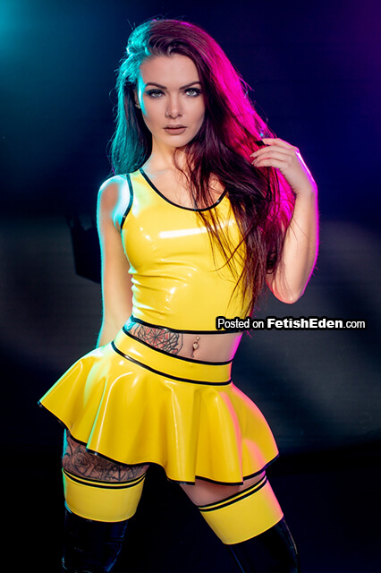 Woman with tattoo in yellow latex top with yellow latex mini-skirt
