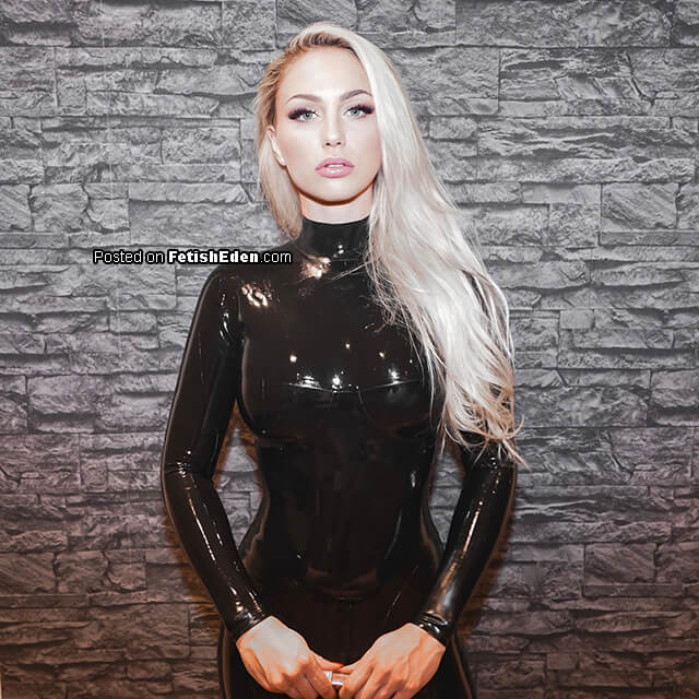 The gloss of black latex catsuit beneath cold stone walls and seductive green eyes – Just Lucy