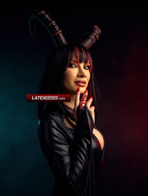 latexcamera red-haired Devil Domme in black wet-look Devil Domme with red hair in a black wet-look outfit with dramatic devil horns in a dark, cinematic setting.